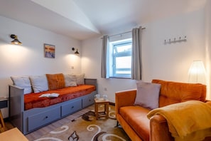 A compact room with a bed, a sofa, a small table, and a window with curtains. - 1 Bed in Birchington (oc-s45228) (Birchington-on-Sea)