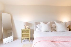 A bedroom with a bed, a bedside table, a mirror, and a nightstand. - 3 Bed in Watergate Bay (oc-b642096) (Tregurrian)
