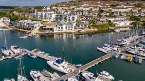 A marina with various boats docked, surrounded by residential buildings. - 2 Bed in Falmouth (oc-b669230) (Flushing)