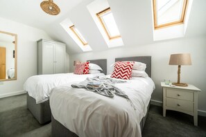 A bedroom with two beds, a wardrobe, a bedside table with a lamp, and skylights. - 2 Bed in Porth (oc-b588797) (Newquay)