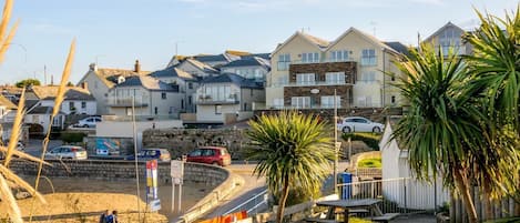 Une zone résidentielle côtière avec des maisons, une plage de sable et un ciel dégagé.