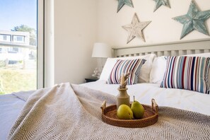 Una habitación de hotel con una cama, una mesita de noche y una ventana con vistas a edificios.