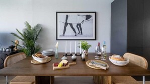 A dining table with a framed artwork, candles, and a variety of food and drink items. - 3 Bed in Hayle (oc-b584309) (Hayle)