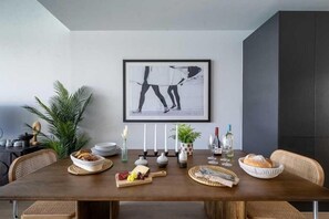 A dining table with a framed artwork, candles, and a variety of food and drink items. - 3 Bed in Hayle (oc-b584309) (Hayle)