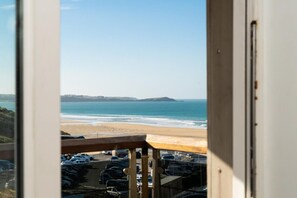 A view of a beach with a parking lot in the foreground. - 2 Bed in Watergate Bay (oc-b590010) (Watergate Bay)