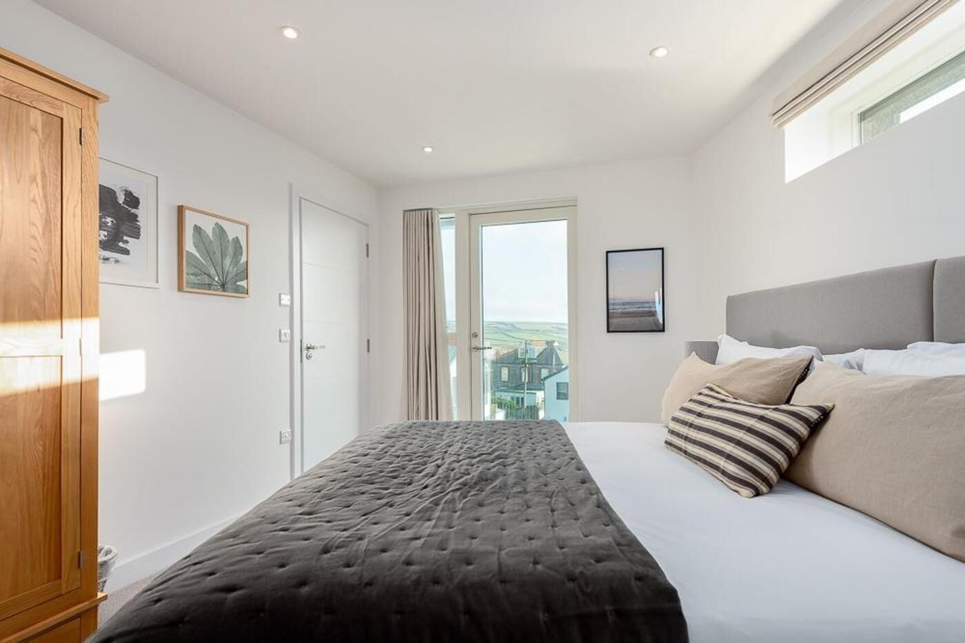 Een slaapkamer met een bed, een kledingkast en een raam met uitzicht.