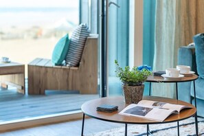 A cozy room with a wooden bench, a small round table with a plant, a magazine, and a cup. - 3 Bed in Perranporth (oc-b584315) (Perranporth)
