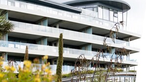 En byggnad med flera våningar, balkonger och en böjd sektion.