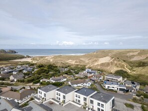 Eine Küstenwohngegend mit Häusern, einem Strand und Dünen.