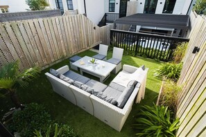 A patio with a sofa set, a table, and chairs. - 4 Bed in Porth (oc-b588791) (Newquay)