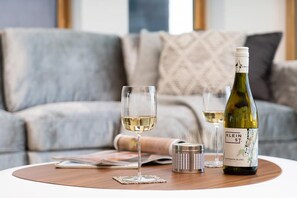 A room with a round table, two wine glasses, a bottle of wine, and a magazine. - 3 Bed in St. Eval (oc-b584290) (Saint Eval)