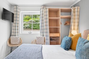 A bedroom with a bed, a wardrobe, a television, and a window with curtains. - 2 Bed in Watergate Bay (oc-b598859) (Tregurrian)