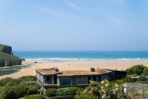 A coastal property with a beach view, a stone building, and a cliff. - 3 Bed in Mawgan Porth (oc-b584450) (Mawgan Porth)