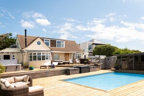 A residential property with a swimming pool, outdoor seating, and a covered patio area. - 5 Bed in Mawgan Porth (oc-b621974) (Mawgan Porth)