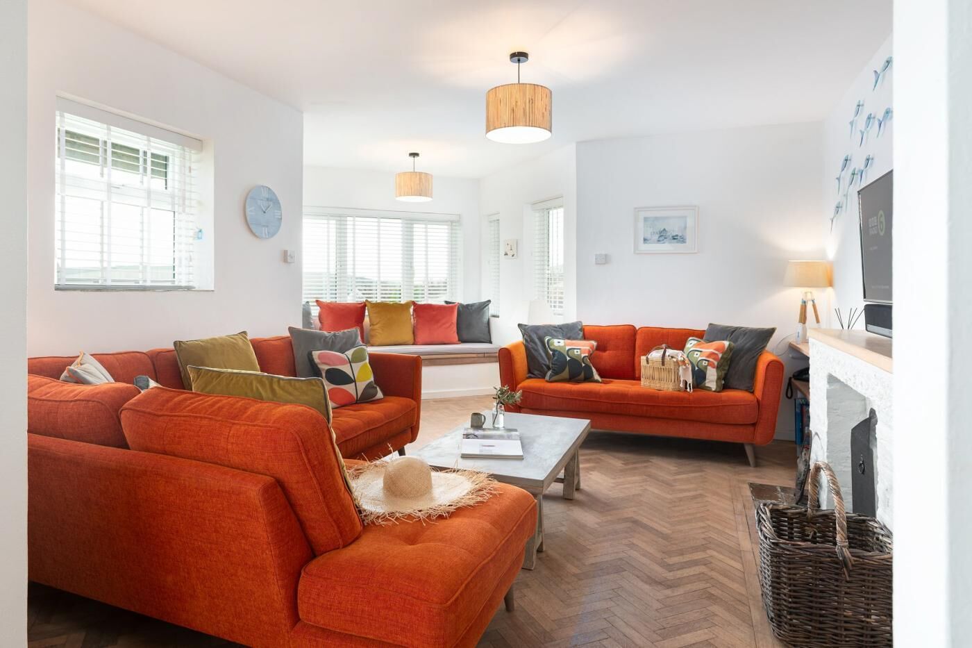 A living room with two orange sofas, a coffee table, and a fireplace.