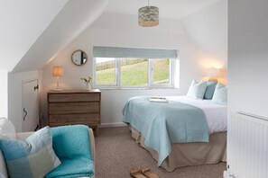 A bedroom with a bed, a dresser, a mirror, a window, and a ceiling light. - 4 Bed in Mawgan Porth (oc-b650080) (Mawgan Porth)