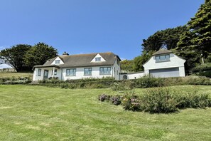 A two-story house with a well-maintained lawn and garden. - 4 Bed in Mawgan Porth (oc-b650080) (Mawgan Porth)