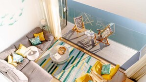 A balcony with a sofa, chairs, a small table, and a glass railing overlooking a pool. - 3 Bed in Hayle (oc-b635644) (Hele)