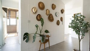 A modern interior with a wall-mounted hat collection, a potted plant, and a minimalist design. - 3 Bed in Downderry (oc-b652220) (Downderry)