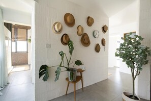 Um interior moderno com uma coleção de chapéus pendurados na parede, uma planta em vaso e design minimalista.