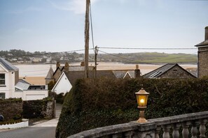 Ein Wohngebiet an der Küste mit Häusern, einer Straßenlaterne und Blick auf den Strand.