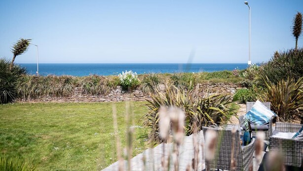 A patio with wicker furniture, a stone pathway, and a view of the ocean. - 2 Bed in Fistral (oc-b625209) (Newquay)