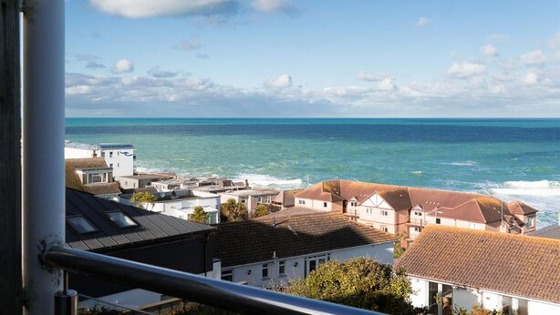 A coastal town with buildings near the sea, a clear sky, and a view of the ocean. - 3 Bed in Fistral (oc-b595429) (Newquay)