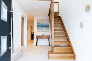 A staircase with wooden steps and a glass door on the left. - 5 Bed in Carbis Bay (oc-b623959) (Carbis Bay)