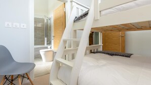 A bunk bed room with a shower, a chair, and a view of the outside. - 3 Bed in Widemouth Bay (oc-b584375) (Widemouth Bay)