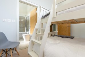A bunk bed room with a shower, a chair, and a view of the outside. - 3 Bed in Widemouth Bay (oc-b584375) (Widemouth Bay)