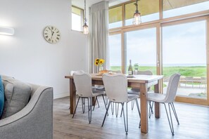 En matplats med ett träbord, fyra stolar, en klocka och utsikt över omgivningen.