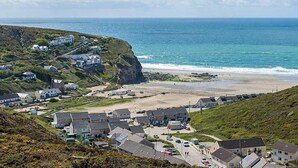 Un pueblo costero con casas en una ladera con vistas al mar.