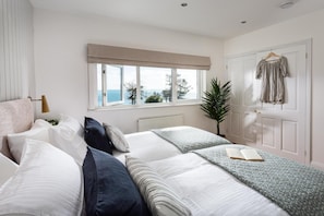 A bedroom with a bed, a window with a view, a door, and a plant. - 4 Bed in Charlestown (oc-b610558) (Charlestown)