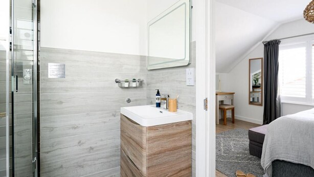 A modern bathroom with a shower, a sink with a mirror, and a vanity with storage. - 4 Bed in Trevone (oc-b637403) (Trevone)