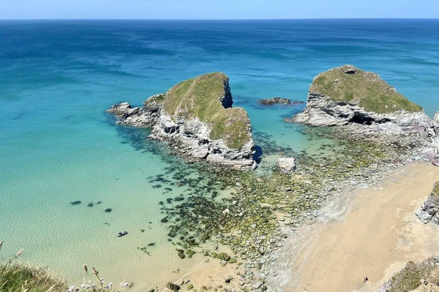 Un paysage côtier caractérisé par des formations rocheuses et une eau d’un bleu limpide.
