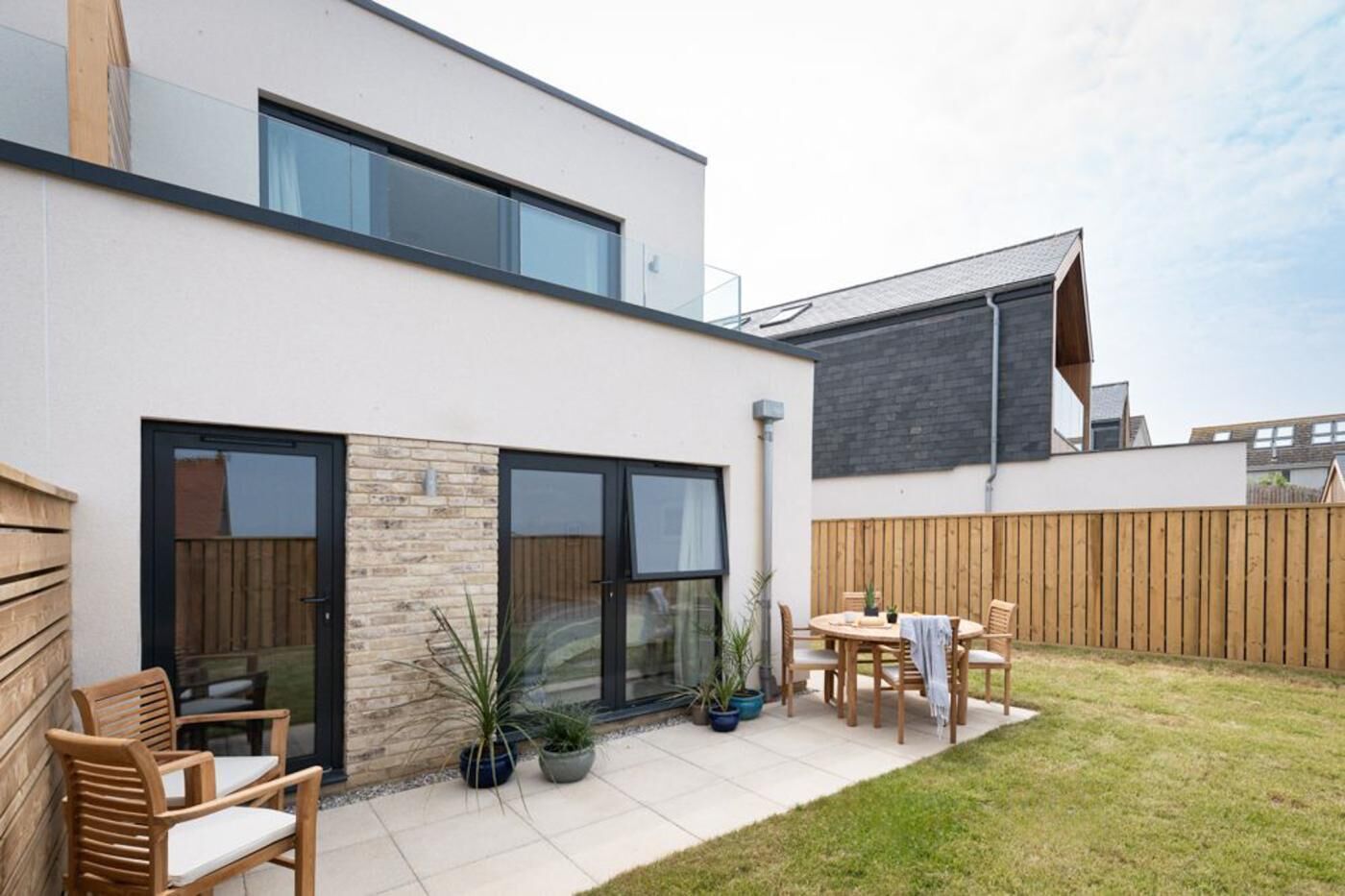 A modern house with a patio, a dining area, and a large window.