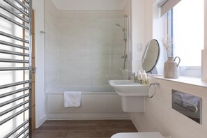 A bathroom with a shower, a sink, and a window. - 4 Bed in Falmouth (oc-b588809) (Goldenbank)