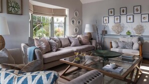 A living room with a sofa, armchairs, a coffee table, and a fireplace. - 4 Bed in The Lizard (oc-b620048) (Coverack)