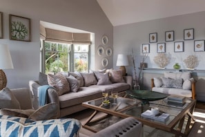 A living room with a sofa, armchairs, a coffee table, and a fireplace. - 4 Bed in The Lizard (oc-b620048) (Coverack)