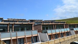 A modern building with multiple levels, large windows, and a flat roof. - 4 Bed in Watergate Bay (oc-b584345) (Tregurrian)