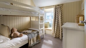 A bunk bed room with a window, a small table, and a teddy bear. - 5 Bed in Porth (oc-b584392) (Newquay)