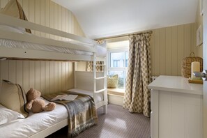 A bunk bed room with a window, a small table, and a teddy bear. - 5 Bed in Porth (oc-b584392) (Newquay)
