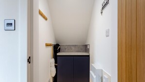 A narrow hallway with a dark-colored cabinet, a towel, and a small countertop. - 2 Bed in Thurso (oc-n41742) (Thurso)