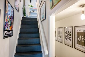 Eine Treppe mit dunkelblauer Handlauf und weißen Wänden.