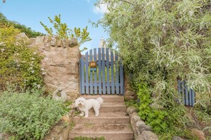 A stone staircase leading to a gated entrance with a dog standing on the steps. - 2 Bed in Dunbar (oc-t42811) (Innerwick)