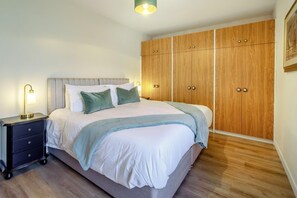 A bedroom with a bed, bedside tables, and a wardrobe. - 4 Bed in Longforgan (oc-w42661) (Longforgan)