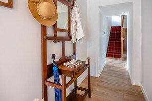 A wooden bench with a welcome mat, a hat, and an umbrella in a hallway. - 4 Bed in Longforgan (oc-w42661) (Longforgan)