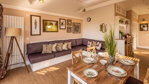 A cozy living room with a sofa, dining table set for four, and a kitchen in the background. - 2 Bed in Wichenford (oc-t45441) (Ockeridge)