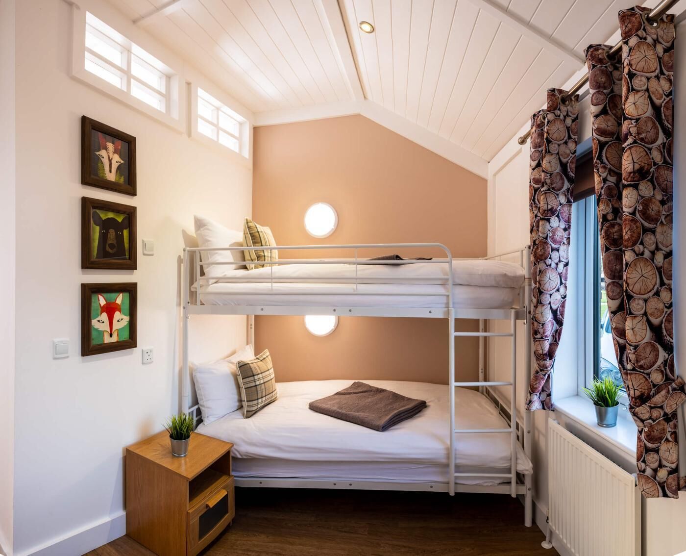 Camera con letto a castello, una piccola scrivania e decorazioni alle pareti.
