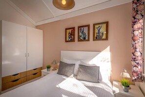 A bedroom with a bed, a wardrobe, a nightstand, a lamp, and wall art. - 2 Bed in Wichenford (oc-t45441) (Ockeridge)